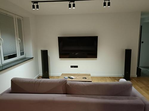 a living room with a couch and a flat screen tv at Apartament 3 Maja 4 in Gorlice