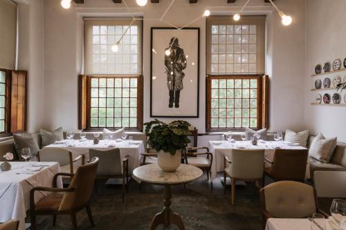 a restaurant with white tables and chairs and a statue at The Alphen Boutique Hotel & Spa in Cape Town