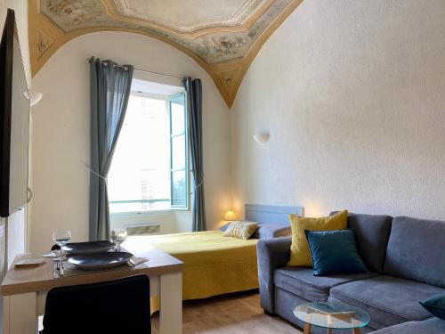 a living room with a couch and a bed at Lovely studio - heart of Menton, near the beach. in Menton