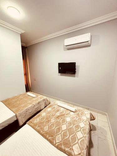 KAMAL HOTEL APARTMENTS في المنصورة: غرفة بسريرين وتلفزيون على الحائط
