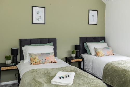 a bedroom with two beds with a game controller on the bed at Lovely House in Welwyn with Garden and Off road parking in Welwyn Garden City