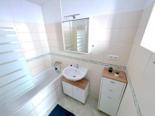 uma casa de banho branca com um lavatório e um espelho em Apartmán u Labe em Děčín