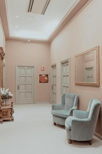 a living room with two chairs and a mirror at Hotel Marisa in Rome