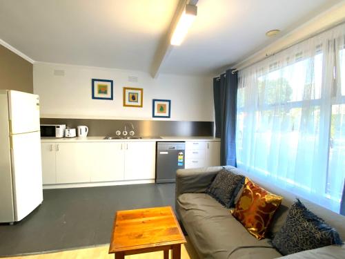 a living room with a couch and a table at Mid Valley Motel in Morwell