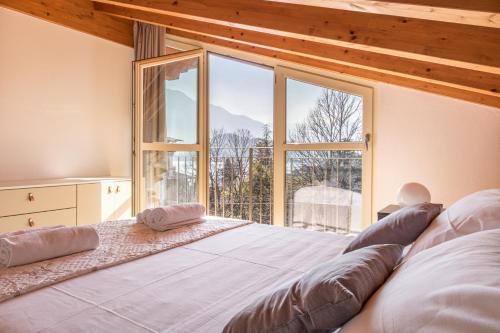 sypialnia z dużym łóżkiem i dużym oknem w obiekcie Apartment Tulipani 9 – Tremezzina w mieście Tremezzo
