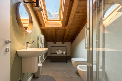 łazienka z umywalką, toaletą i oknem w obiekcie Apartment Tulipani 9 – Tremezzina w mieście Tremezzo