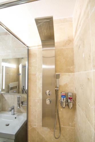 une douche dans une salle de bain avec un lavabo dans l'établissement Front de Mer, à Hendaye