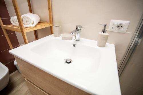 La salle de bains est pourvue d'un lavabo blanc et d'une douche. dans l'établissement La Casetta di nonna Olga-Chalet, à Agerola
