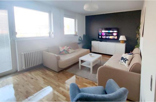 a living room with two couches and a tv at Apartments Zagreb Point in Zagreb