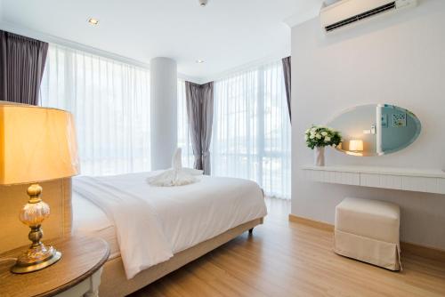 een witte slaapkamer met een bed en een spiegel bij Huahin Myresort Family Suite Condo 3B2B Free water park มายรีสอร์ท หัวหิน 3 ห้องนอน 2 ห้องน้ำ พัก 8 คน ฟรีสวนน้ำ in Hua Hin