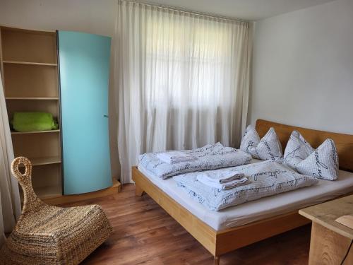 1 dormitorio con 1 cama, 1 silla y 1 ventana en Gästehaus Mangold Fritsch en Klaus