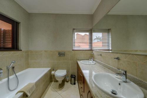uma casa de banho com uma banheira, um WC e um lavatório. em San Lameer Villa - 14328 - 4 Bedroom Deluxe - 8 pax - San Lameer Rental Agency em Southbroom