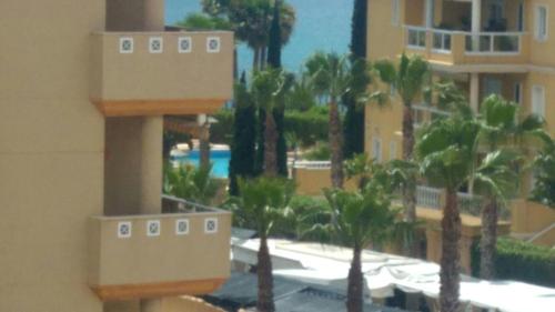 een uitzicht op een resort met palmbomen en een zwembad bij Costamarina Apartment Top Floor in Cabo Roig