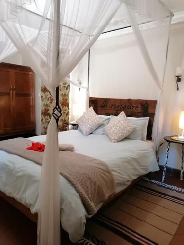 a bedroom with a bed with a canopy at Foundation Lodge in Sodwana Bay