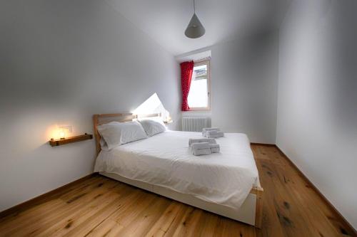 博爾米奧的住宿－Baita Skianta 3，一间卧室配有一张带白色床单的床和一扇窗户。