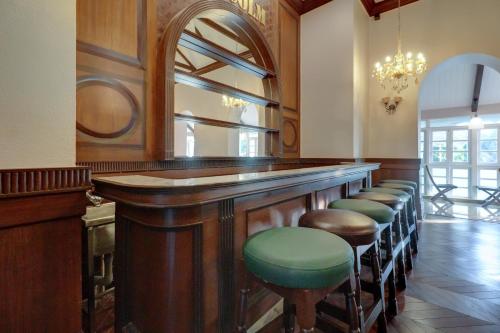 a bar with a row of stools in a room at Citrus Chambers Mahabaleshwar in Mahabaleshwar