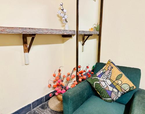 a green couch with a pillow and a vase of flowers at Hotel Darwin in Kathmandu