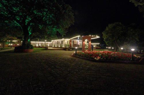 a building lit up at night with flowers and lights at Citrus Chambers Mahabaleshwar in Mahabaleshwar