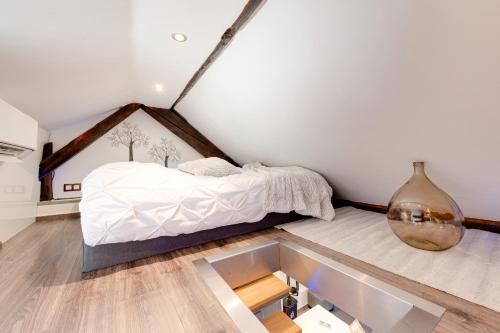 Un dormitorio con una cama en la esquina de una habitación. en Le Duplex atypique superbe coeur centre ville, en Annecy