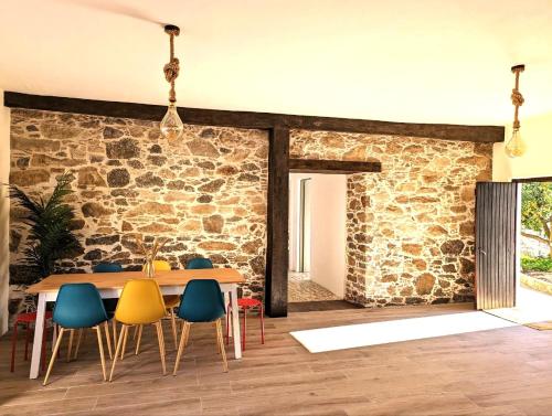 a dining room with a stone wall and a table and chairs at Cozy 3 BR Home - Close to Beach in Lourinhã