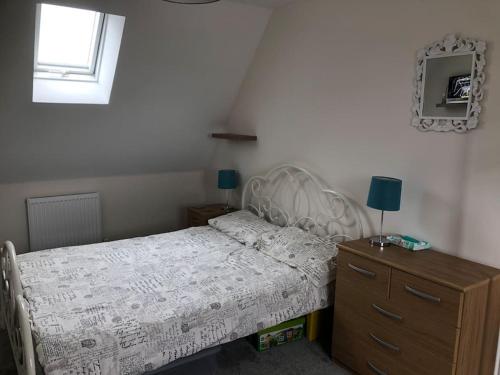 ein Schlafzimmer mit einem Bett, einer Kommode und einem Fenster in der Unterkunft 4 bedroom luxurious detached home in Liskeard