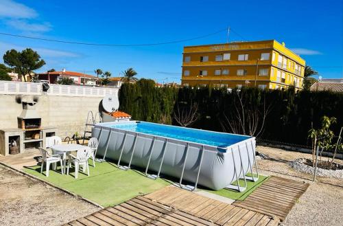 a swimming pool with a table and chairs next to a building at The House in Casas Devesa