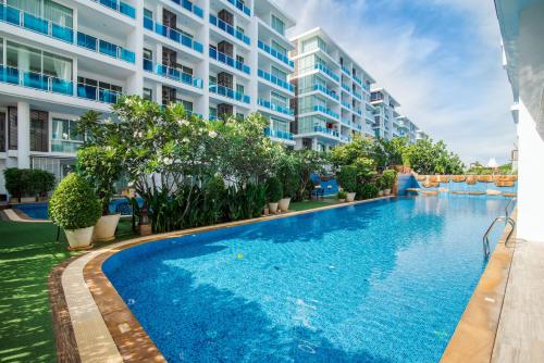 a swimming pool in front of a building at Huahin Myresort Family Suite Condo 3B2B Free water park มายรีสอร์ท หัวหิน 3 ห้องนอน 2 ห้องน้ำ พัก 8 คน ฟรีสวนน้ำ in Hua Hin