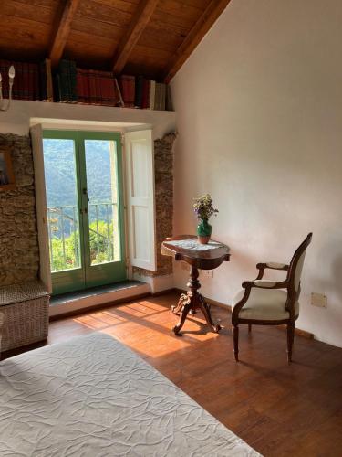 a room with a table and a chair and a window at Casa Olivia Lacremà in Finale Ligure