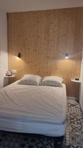 a bed with white sheets and pillows in a bedroom at Appartement Cosy Saint Cyprien in Saint-Cyprien