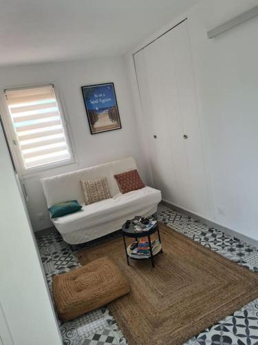 a living room with a white couch and a table at Appartement Cosy Saint Cyprien in Saint-Cyprien