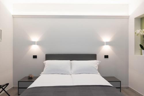 a bedroom with a white bed with two tables and two lamps at Amiata Suite in Abbadia San Salvatore