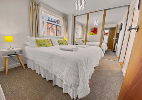 a bedroom with two beds and a mirror at Waterfront Quay in Gosport