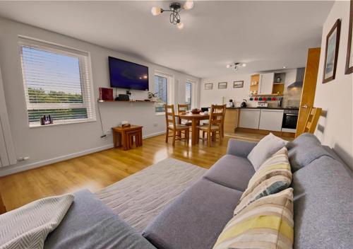 a living room with a blue couch and a kitchen at Waterfront Quay in Gosport