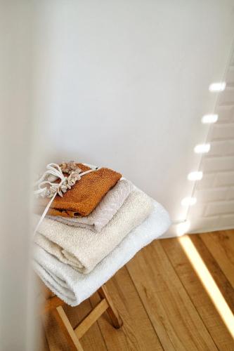 une pile de serviettes assises sur un tabouret dans une pièce dans l'établissement LA MAISON d'HORTENSE, maison de charme et de caractère, à Toulouse