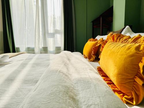 a bed with orange and white sheets and pillows at Hotel Darwin in Kathmandu