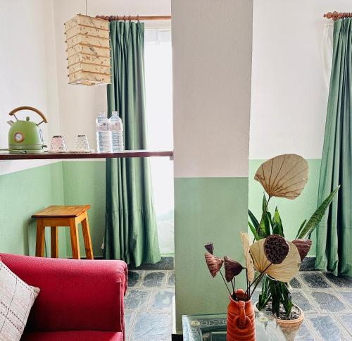 a living room with a red couch and a table with a plant at Hotel Darwin in Kathmandu