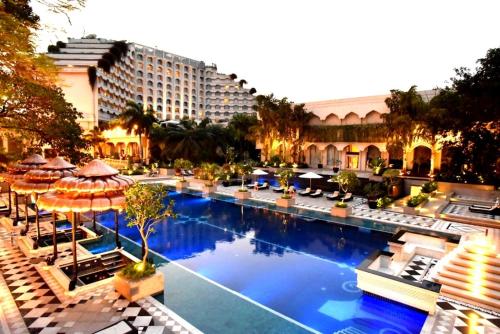 an image of a hotel pool with chairs and umbrellas at Taj Krishna in Hyderabad