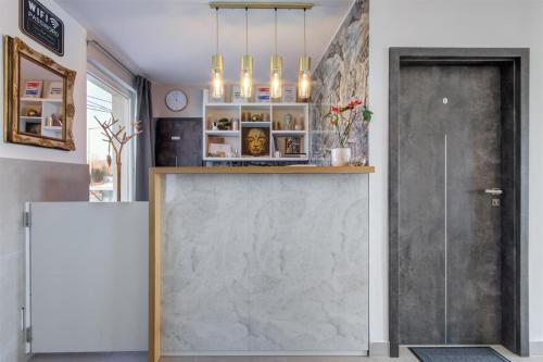 a lobby with a stone wall and a door at Duna P'Art Panzió in Kismaros