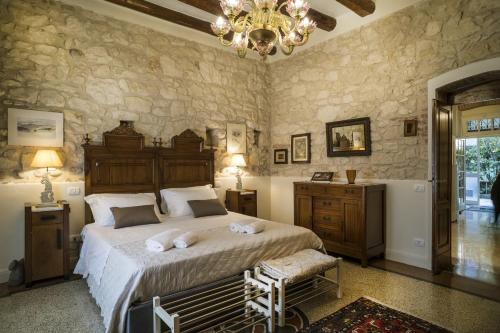 Un dormitorio con una cama grande y una lámpara de araña. en Il Calamaio en Verona