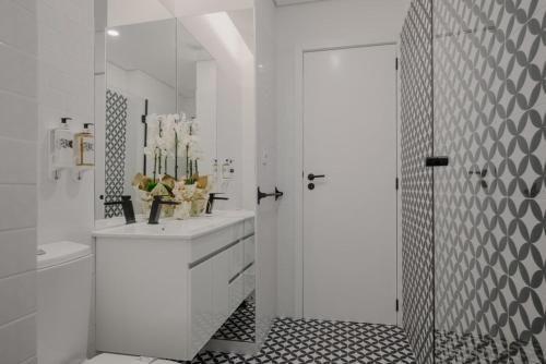 La salle de bains blanche est pourvue d'un lavabo et d'une douche. dans l'établissement Green Garden Luxury House w/ AC, Metro & Downtown, à Porto