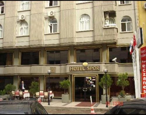 un hotelero con mesas y sillas frente a un edificio en SPOR HOTEL, en Ankara