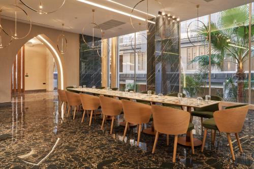 a long dining room with a long table and chairs at Nautilux Rethymno by Mage Hotels in Rethymno Town
