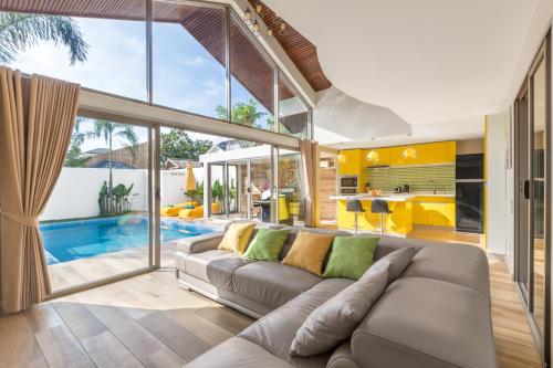 - un salon avec un canapé et une piscine dans l'établissement Ban Tai Estate Premium Villas, à Koh Samui 