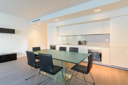 a kitchen with a glass table and black chairs at [Lakefront Apartment] Private Parking and Pool in Laglio