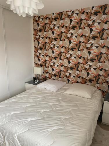a bedroom with a large white bed with a wall at CHAMBRE D'HÔTE COSY Hiriburu in Saint-Pierre-dʼIrube