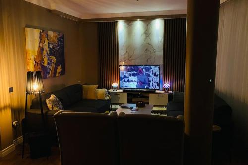een woonkamer met een bank en een flatscreen-tv bij Sisli Osmanbey Taksim large terrace, quietness and space in Istanbul
