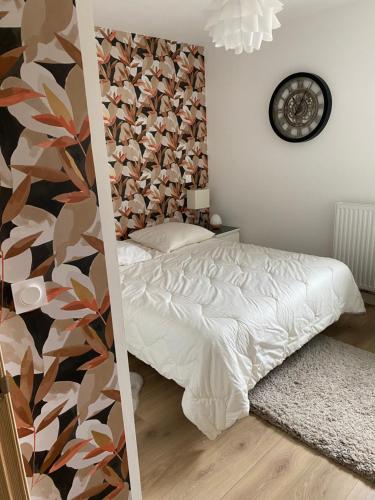 a bedroom with a bed and a floral wall at CHAMBRE D'HÔTE COSY Hiriburu in Saint-Pierre-dʼIrube