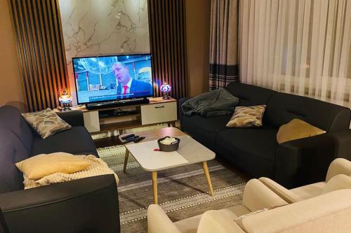 een woonkamer met 2 banken en een flatscreen-tv bij Sisli Osmanbey Taksim large terrace, quietness and space in Istanbul