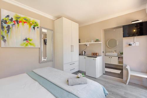a bedroom with a white bed and a bathroom at 2 On Lismore Guesthouse in Tokai
