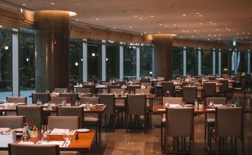 a dining room filled with tables and chairs at LOTTE Hotel Serviced Apartment in Yangon